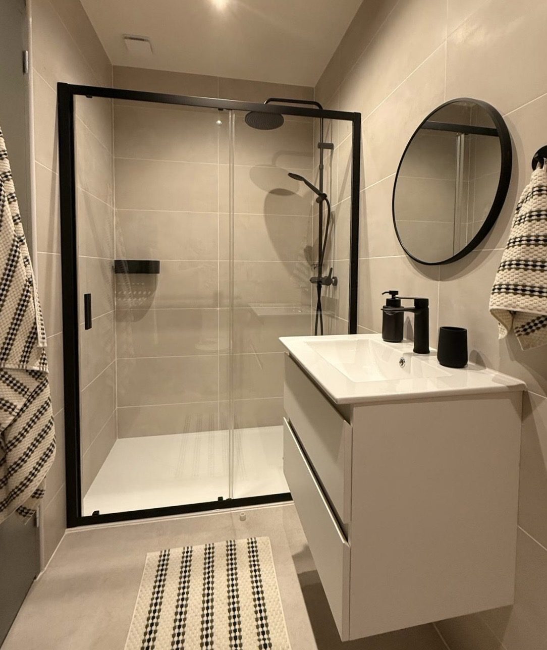 Salle d'eau avec douche et miroir rond