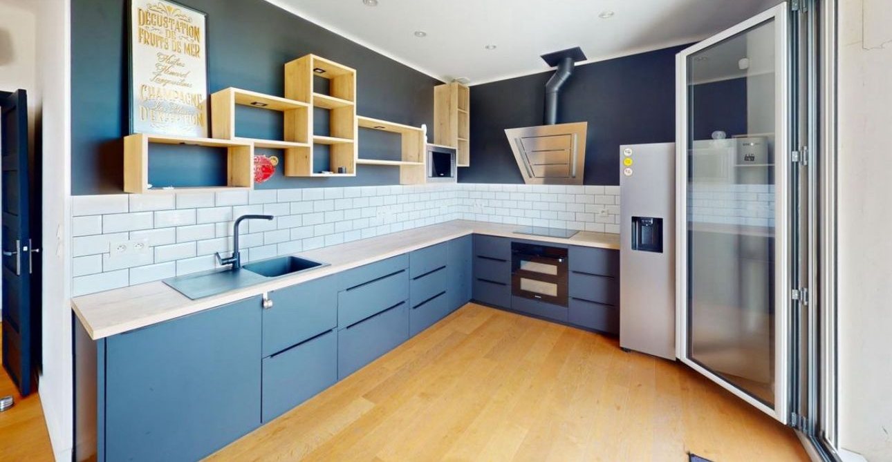 La cuisine d'origine, façades bleues et mur sombre